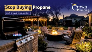 Outdoor gas grill and fire pit on stone patio at dusk